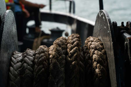 Rope on a sea boat for mooring a vessel is adhered to a pier.の写真素材