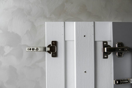 Furniture loop for a chipboard, installed on a white and grey kitchen fronts from mdf material....