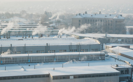 The factory chimneys are smoking during a winter season. The concept of air pollution. Environmental...