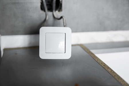 Repair or installation of a new light switch in the wall. Light switch connected via cables to a electricity in a home.の写真素材