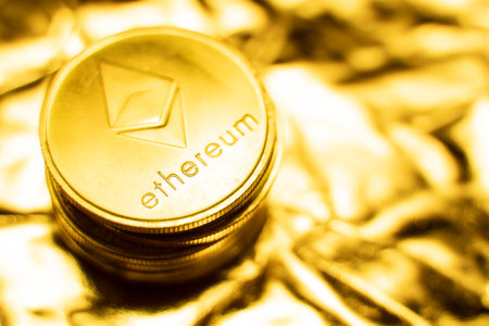 Gold ethereum coins on a golden background. Trading on the cryptocurrency exchange. Cryptocurrency Stock Market Concept. Virtual money concept. Mining or blockchain technology. Business concept.の写真素材