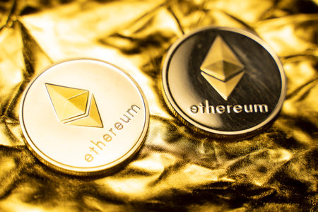 Gold ethereum coins on a golden background. Trading on the cryptocurrency exchange. Cryptocurrency...