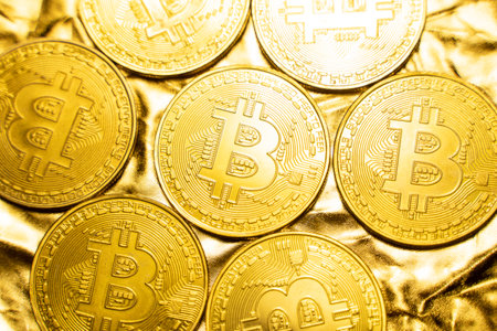 Golden bitcoin Coins on a golden background. Trading on the cryptocurrency exchange. Cryptocurrency Stock Market Concept. Virtual money concept. Mining or blockchain technology. Business concept.の写真素材