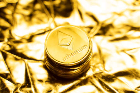 Gold ethereum coins on a golden background. Trading on the cryptocurrency exchange. Cryptocurrency Stock Market Concept. Virtual money concept. Mining or blockchain technology. Business concept.の写真素材