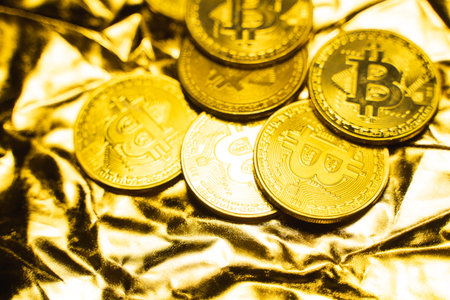 Golden bitcoin Coins on a golden background. Trading on the cryptocurrency exchange. Cryptocurrency...