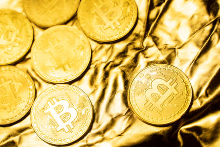Golden bitcoin Coins on a golden background. Trading on the cryptocurrency exchange. Cryptocurrency Stock Market Concept. Virtual money concept. Mining or blockchain technology. Business concept.の写真素材