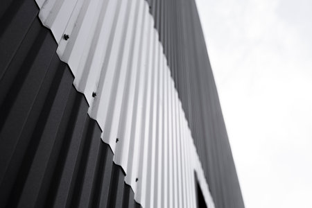 Black and white corrugated iron sheet used as a facade of a warehouse or factory. Texture of a...