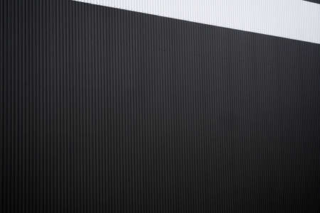 Black and white corrugated iron sheet used as a facade of a warehouse or factory. Texture of a seamless corrugated zinc sheet metal aluminum facade. Architecture. Metal texture.の写真素材