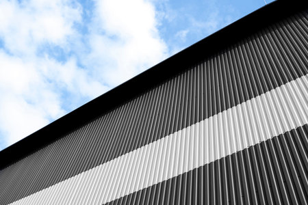 Black and white corrugated iron sheet used as a facade of a warehouse or factory. Texture of a...