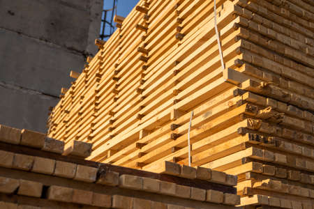 Storage of piles of wooden boards on the sawmill. Boards are stacked in a carpentry shop. Sawing drying and marketing of wood. Pine lumber for furniture production, construction. Lumber Industry.の写真素材