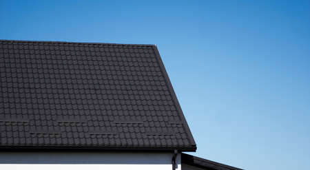 Brown corrugated metal profile roof installed on a modern house. The roof of corrugated sheet. Roofing of metal profile wavy shape. Modern roof made of metal. Metal roofing.の写真素材