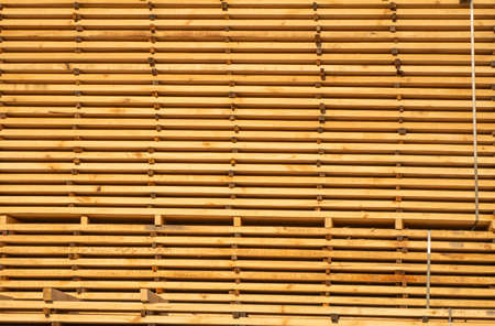 Storage of piles of wooden boards on the sawmill. Boards are stacked in a carpentry shop. Sawing drying and marketing of wood. Pine lumber for furniture production, construction. Lumber Industry.の写真素材