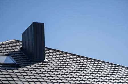 Brown corrugated metal profile roof installed on a modern house. The roof of corrugated sheet. Roofing of metal profile wavy shape. Modern roof made of metal. Metal roofing.の写真素材