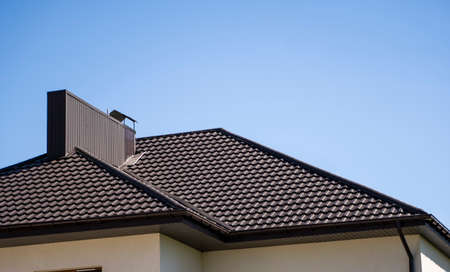 Brown corrugated metal profile roof installed on a modern house. The roof of corrugated sheet. Roofing of metal profile wavy shape. Modern roof made of metal. Metal roofing.の写真素材