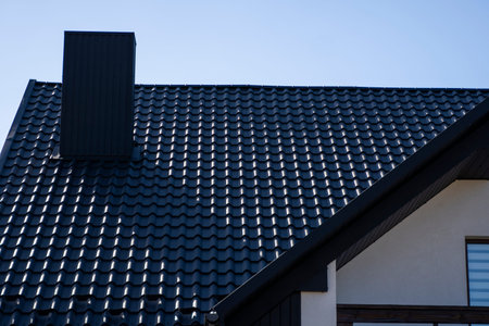 Grey corrugated metal profile roof installed on a modern house. The roof of corrugated sheet....