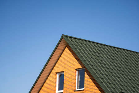 Green corrugated metal profile roof installed on a modern house. The roof of corrugated sheet. Roofing of metal profile wavy shape. Modern roof made of metal. Metal roofing.の写真素材