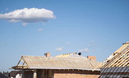 Wooden roof construction against blue sky. House building.の写真素材