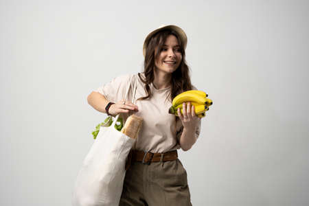 Zero waste concept. Young woman holding reusable cotton shopping bag with groceries from a market. Concept of no plastic. Zero waste, plastic free. Eco friendly concept. Sustainable lifestyle.の写真素材