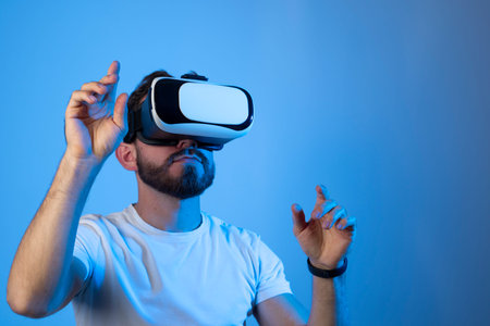 Bearded man using VR headset helmet to interacts with metaverse using swipe and stretching gestures....