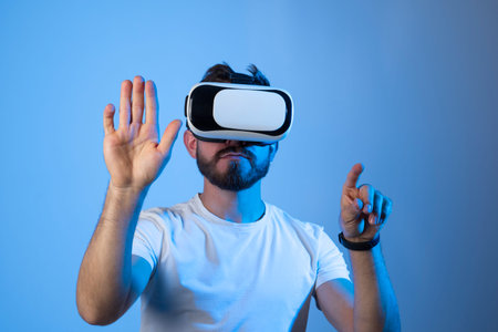 Bearded man with glasses of virtual reality in a neon light. Future technology concept. Young man...