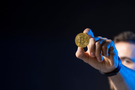 Cryptocurrency concept. Young bearded man holding virtual currency bitcoin coin. Crypto trader holding a btc coin. Cryptocurrency.の写真素材
