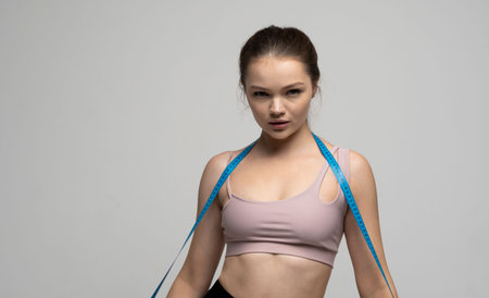 Young beautiful brunette woman in sport outfit after fitness. Weight loss and diet concepts.