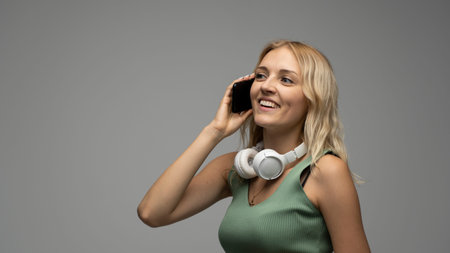 Closeup photo of attractive positive laughing young blonde woman communicating on mobile phone and...