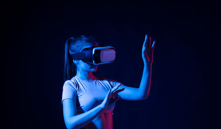 Portrait of female architector wearing virtual reality headset and making gestures with hands, she...