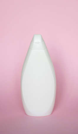 White plastic soap shampoo bottle isolated on pink background. Skin care lotion. Bathing essential product. Shampoo bottle. Bath and body lotion. Fine liquid hand wash. Bathroom accessories.の写真素材