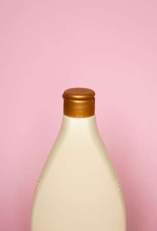Beige plastic soap or shampoo bottle isolated on pink background. Skin care lotion. Bathing essential product. Shampoo bottle. Bath and body lotion. Fine liquid hand wash. Bathroom accessories.の写真素材
