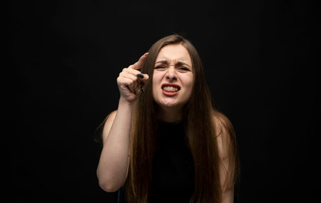 Negative human emotions and feelings. Grumpy angry young woman posing, frowning eyebrows, her look...