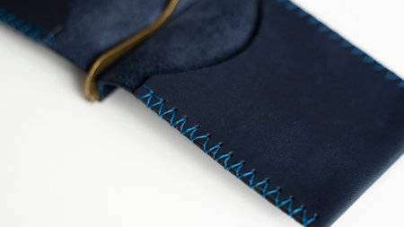 Open empty blue money clip handmade from genuine leather on white surface.