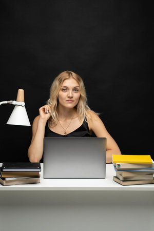 Young smiling freelancer woman using laptop for remote work, e-learning at university college,...