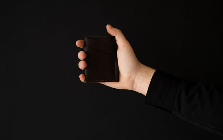 Brown empty mens business handmade leather card holder in a mans hand.