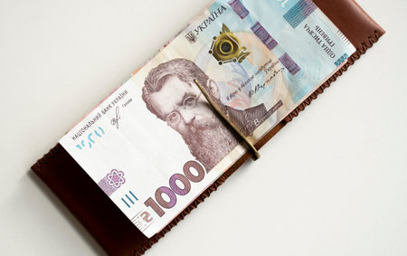 Brown leather money clip, purse with ukrainian hryvnia banknotes. Mens genuine leather wallet. Accessories. Money, financess, economy, saving.の写真素材