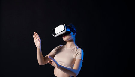Woman in VR headset looking up at the objects in virtual reality while playing a game or watching 3d movie. Future technology concept.の写真素材
