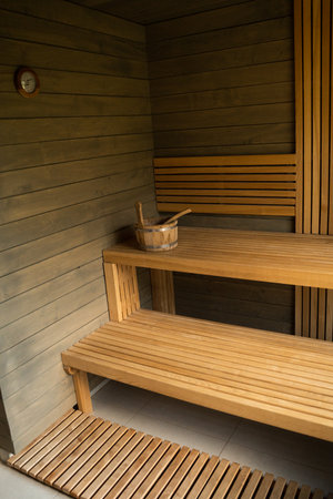 Modern wooden Finnish sauna interior with wooden benches. Wooden interior baths, wooden benches and loungers accessories for sauna, spa complex.の写真素材