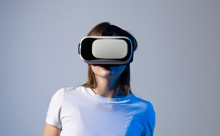 Brunette woman in VR headset looking up at the objects in virtual reality. Woman experience with virtual reality. Lady excited first virtual reality experience try to touch objects.の写真素材