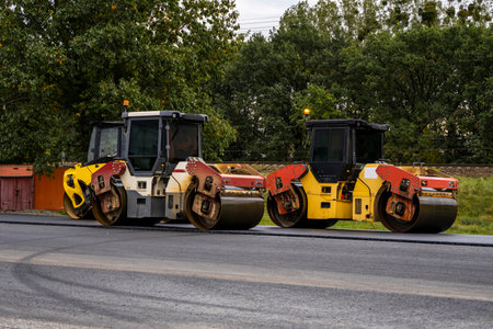 Two road rollers parked on highway construction siteの写真素材