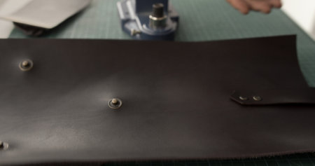 Setting hardware on leather pieceの写真素材