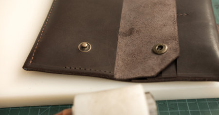 Close-up of handmade leather wallet with button flapの写真素材