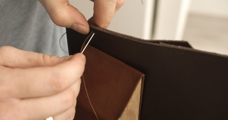Leather flap stitching by hand on brown walletの写真素材