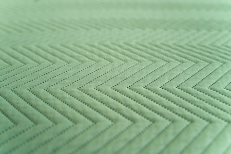 Detailed quilted green fabric with alternating zigzag geometric patternの写真素材