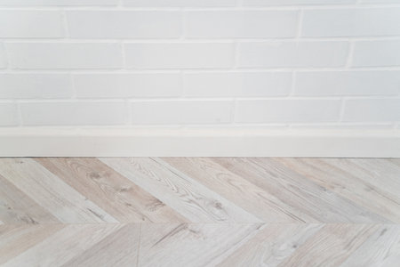 White painted brick wall and wooden floor with clean minimalistic textureの写真素材