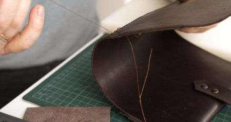 Sewing leather bag with strong thread and needle, artisan crafting process