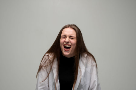 Young woman screaming loudly, expressing intense anger, stress, frustration, and emotional breakdown...