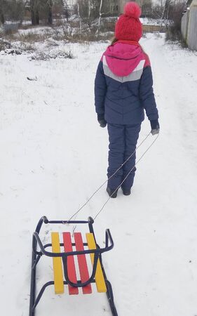 girl go sledding downhillの写真素材