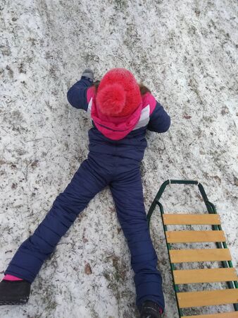 girl sledding from the mountainの写真素材