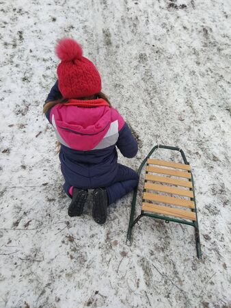 girl sledding from the mountainの写真素材