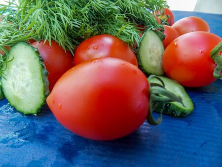 tomatoes and cucumbers on a blue backgroundの写真素材
